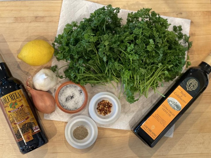 The ingredients of Elizabeth Karmel's Blender Chimichurri Sauce are shown in this photo by the author. Right to Left they are, sherry vinegar, shallot, garlic, lemon, curly parsley, olive oil, chili flakes, salt and white pepper.