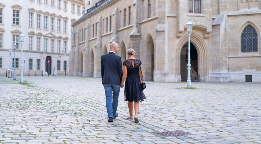 A couple walks on cobblestones in Vienna