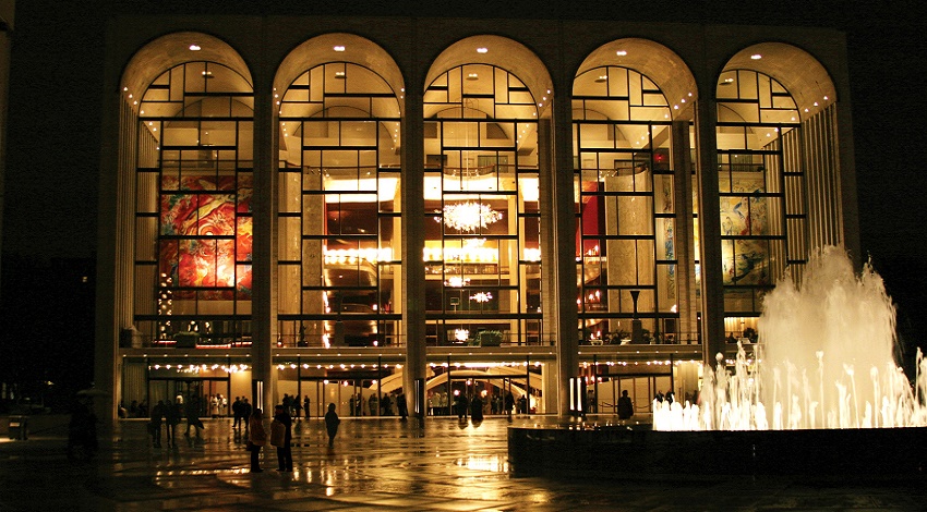 The exterior of the Metropolitan Opera House in New York City, with tall archways and a fountain in front