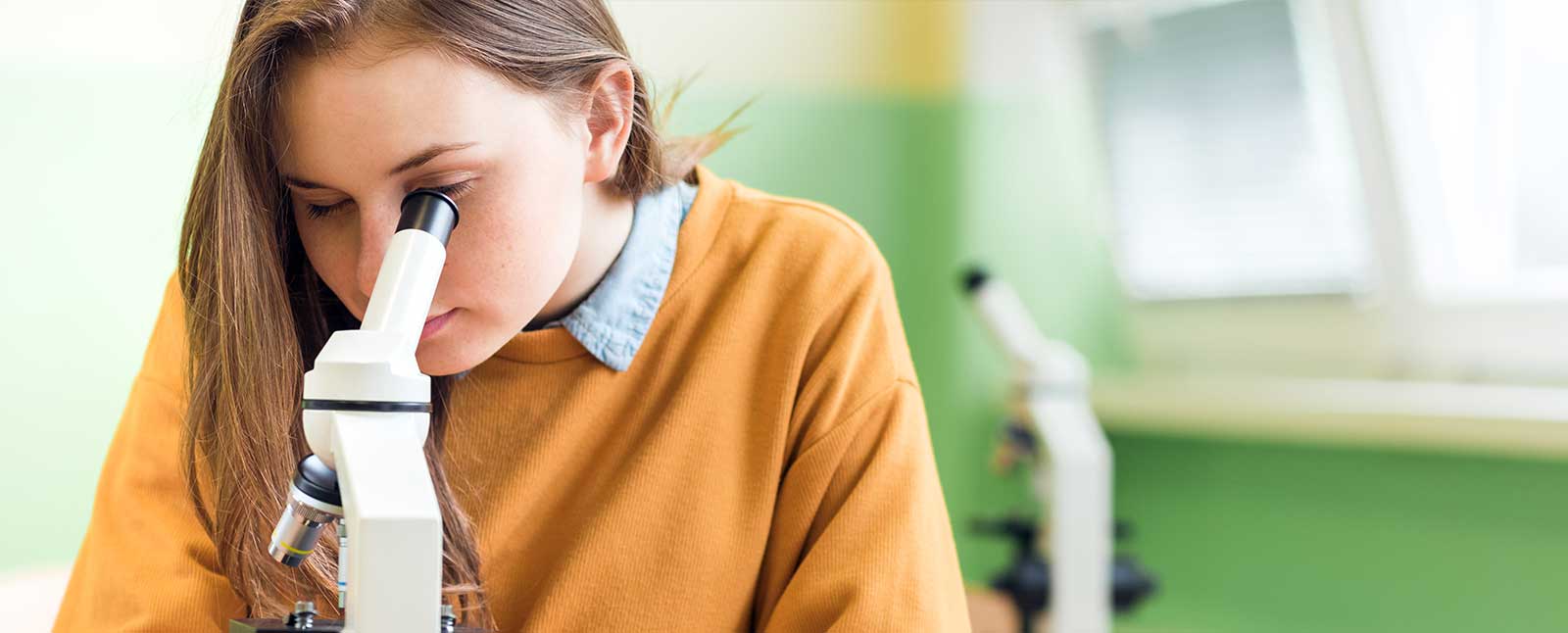 Girl looking into a microscope