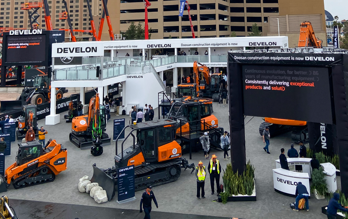 Photo from a distance of the DEVELON CONEXPO booth with visitors checking out a variety of DEVELON machines.