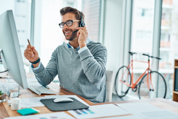 Man talking on headset in from of desktop Man talking on headset in from of desktop