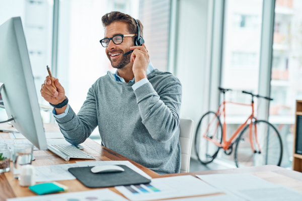 Man talking on headset in from of desktop