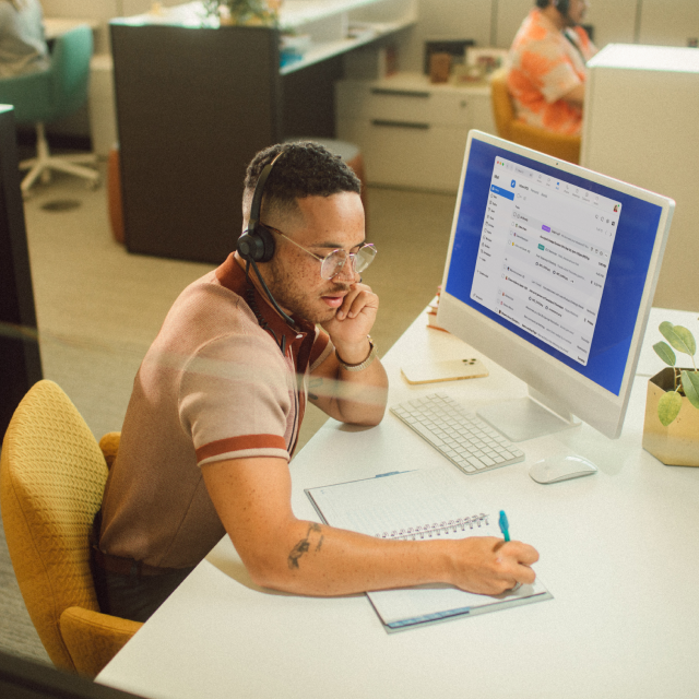Mailcalender_Client_Hero_IMG Man at office desk on phone