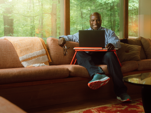 Survey Flex Work Hero Man on couch with laptop desk