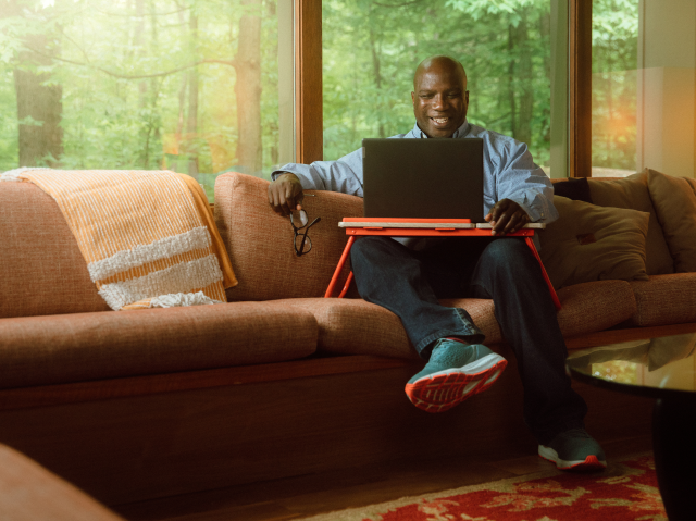 Man on couch with laptop desk