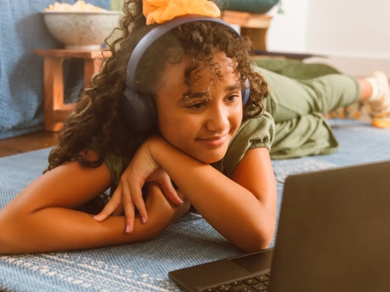 kid laying on floor in front of laptop