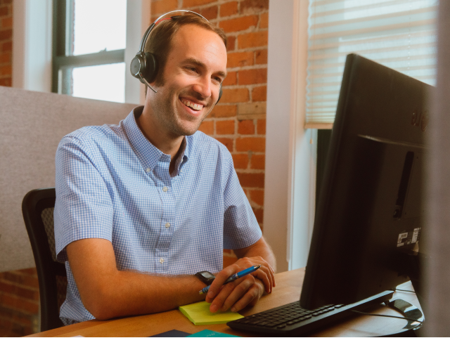 Smiling Man Customer Service Man looking at monitor